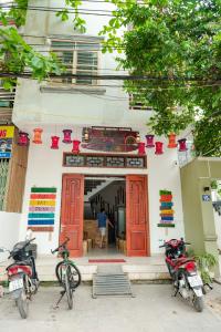 twee motorfietsen geparkeerd voor een gebouw met rode deuren bij Rainbow House Ha Giang in Ha Giang