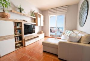 a living room with a couch and a television at Apartamento junto al mar en costa tropical y Alpujarras granadinas in Melicena