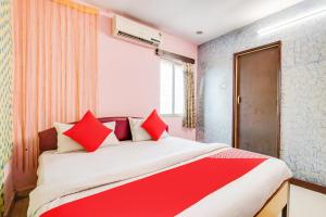 sypialnia z dużym łóżkiem z czerwonymi poduszkami w obiekcie SPOT ON Hotel Wonderfull Inn w mieście Visakhapatnam