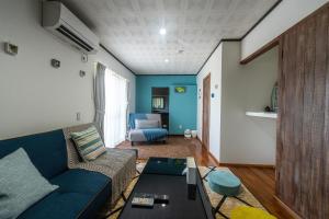 sala de estar con sofá azul y mesa en private house noko, en Isla Miyako