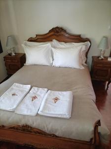 1 cama con 2 toallas blancas y 2 mesitas de noche en Family House Cup- Quinta das Pinheirinhas en Tomar