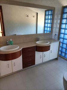 un bagno con due lavandini e un grande specchio di Family House Cup- Quinta das Pinheirinhas a Tomar
