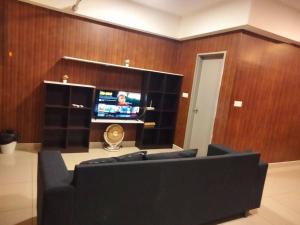 un soggiorno con divano e TV a schermo piatto di HB816 -Cyberjaya-Netflix-Wifi-Parking, 3036 a Cyberjaya