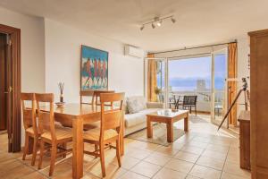 een woonkamer met een tafel en een bank bij Sunny Beach Apartment in Estepona