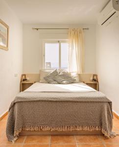1 dormitorio con 1 cama grande y ventana en Sunny Beach Apartment, en Estepona