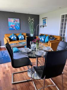 uma sala de estar com uma mesa e um sofá em CockleDora, A Luxury Ground Floor Beachfront Apartment em Llanelli