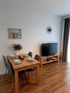 una sala da pranzo con tavolo e TV di Apartament Green Park 2 a Starogard Gdański