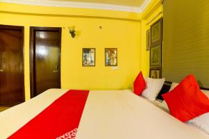 DānāpurにあるHotel O Cafe Garden Villaのベッドルーム1室(大型ベッド1台、赤と白の枕付)