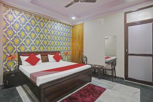 a bedroom with a bed and a colorful wall at Hotel Metro Inn Near Worlds Of Wonder in Kalkaji Devi