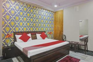 um quarto com uma cama e uma parede colorida em Hotel Metro Inn Near Worlds Of Wonder em Kālkāji Devi