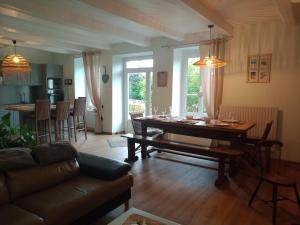 een woonkamer met een houten tafel en een eetkamer bij DOMAINE DES TISSEYS vue sur le Mont St Michel in Dragey