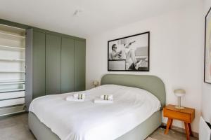 um quarto com uma grande cama branca com uma fotografia na parede em Le Panoramic Gardéen - Welkeys em La Garde