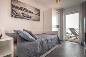 a bedroom with a bed and a view of the ocean at Casa Alegria Barra Deluxe by Home Sweet Home Aveiro in Gafanha da Nazaré