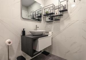 uma casa de banho com um lavatório e um espelho em Casa Alegria Barra Deluxe by Home Sweet Home Aveiro em Gafanha da Nazaré