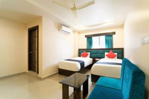 een hotelkamer met 2 bedden en een blauwe stoel bij Hotel Seatree in Raspari Palao