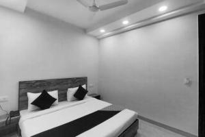 a bedroom with a bed with black and white pillows at Flagship Comfort Residency Near Artemis Hospital in Gurgaon