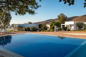 uma piscina em frente a uma casa com montanhas ao fundo em Lunja Village - Agadir em Taghazout