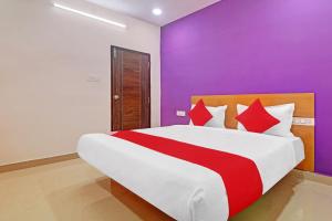 a bedroom with a large bed with purple walls at Hotel O Langar Houz Near Golconda Fort in Hyderabad