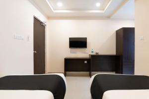 a room with two beds and a flat screen tv at Hotel Seatree in Raspari Palao