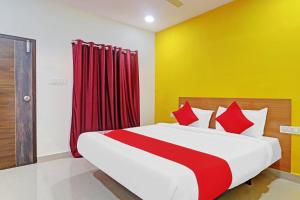 a bedroom with a bed with red and yellow walls at Hotel O Langar Houz Near Golconda Fort in Hyderabad