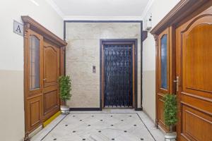 a door in a hallway with two potted plants at Capital O Hotel Samrat Palace Near Nampally Station in Hyderabad