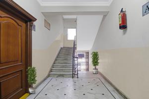 a hallway with stairs and a fire extinguisher on the wall at Capital O Hotel Samrat Palace Near Nampally Station in Hyderabad