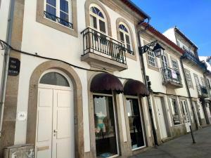 a building with a white door on a street at Almeida's House in Viana do Castelo