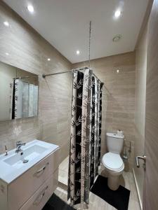 y baño con aseo blanco y lavamanos. en Appartement de luxe a Marrakech, en Marrakech