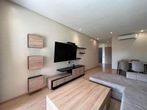 sala de estar con TV de pantalla plana en la pared en Appartement de luxe a Marrakech, en Marrakech