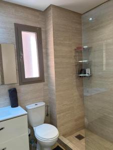 y baño con aseo y ducha acristalada. en Appartement de luxe a Marrakech, en Marrakech