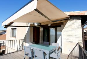 eine Terrasse mit einem Tisch und Stühlen auf dem Balkon in der Unterkunft Casa Sierra de Guara in Adahuesca