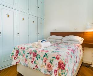 a bedroom with a bed with a floral bedspread at Quarto e Sala Coraçao do Leblon in Rio de Janeiro