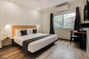 a bedroom with a large bed and a window at Townhouse Begumpet Near Hyderabad Central in Ameerpet