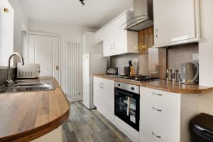 una cocina con armarios blancos y fregadero en Freshly Renovated, Feels Like Home, Sleeps 3, en Chester-le-Street