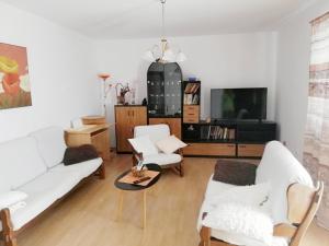sala de estar con 2 sofás blancos y TV en Apartment Ivy, en Ližnjan