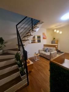 - un salon avec un escalier et un canapé dans l'établissement Muji-Inspired, Studio-Type Home at Phirst Park Homes Tanza, à Tanza