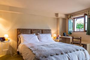 ein Schlafzimmer mit einem Bett mit zwei Tischen und zwei Fenstern in der Unterkunft B&B Il Poggio di Gavi in Gavi