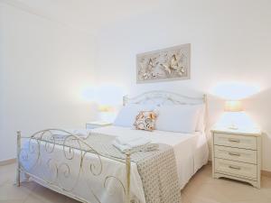 1 dormitorio con cama blanca y mesita de noche en Soraya Holidays Home, en Leuca