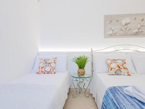 2 camas en una habitación con mesa en Soraya Holidays Home, en Leuca