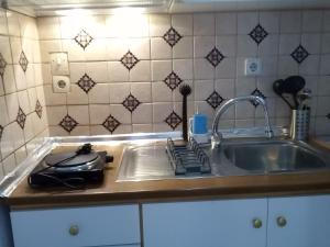 a kitchen counter with a sink and a stove at Studios Thomas in Limenaria