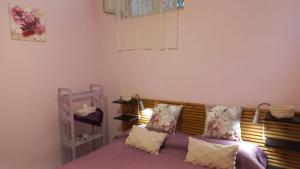 - une chambre avec un lit doté de draps et d'oreillers violets dans l'établissement Delizia Caprese, à Massa Lubrense