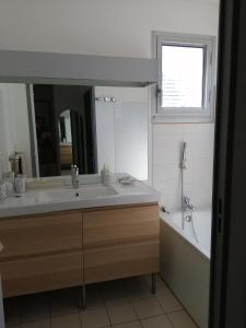 a bathroom with a sink and a tub and a mirror at Tee 4 in Nîmes