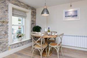 uma sala de jantar com uma mesa de madeira e cadeiras em Shrubbery Mews Luxury Apartment em Kenmare