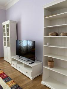 カルロヴィ・ヴァリにあるJurincom Apartments Vilenaのリビングルーム(テレビ、白い棚付)