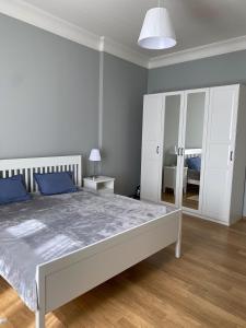 カルロヴィ・ヴァリにあるJurincom Apartments Vilenaの白いベッドルーム(大型ベッド1台、鏡付)