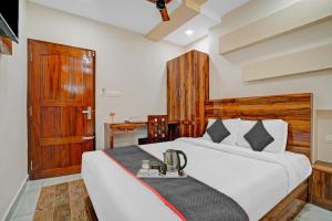 a bedroom with two beds and a wooden door at Super Capital O Krishnakripa Executive Stay in Muttam