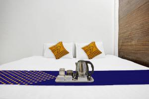 SPOT ON Friends Service Appartment في ناغبور: غرفة في الفندق مع سرير مع غلاية شاي