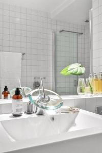 a white bathroom with a sink and a mirror at Tjuvholmen / Aker Brygge - Most expensive area in Oslo! in Oslo