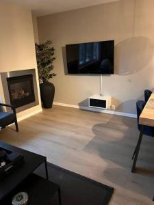 uma sala de estar com uma televisão de ecrã plano na parede em Tjuvholmen / Aker Brygge - Most expensive area in Oslo! em Oslo