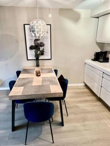 a dining room table with blue chairs and a chandelier at Tjuvholmen / Aker Brygge - Most expensive area in Oslo! in Oslo +37 photos